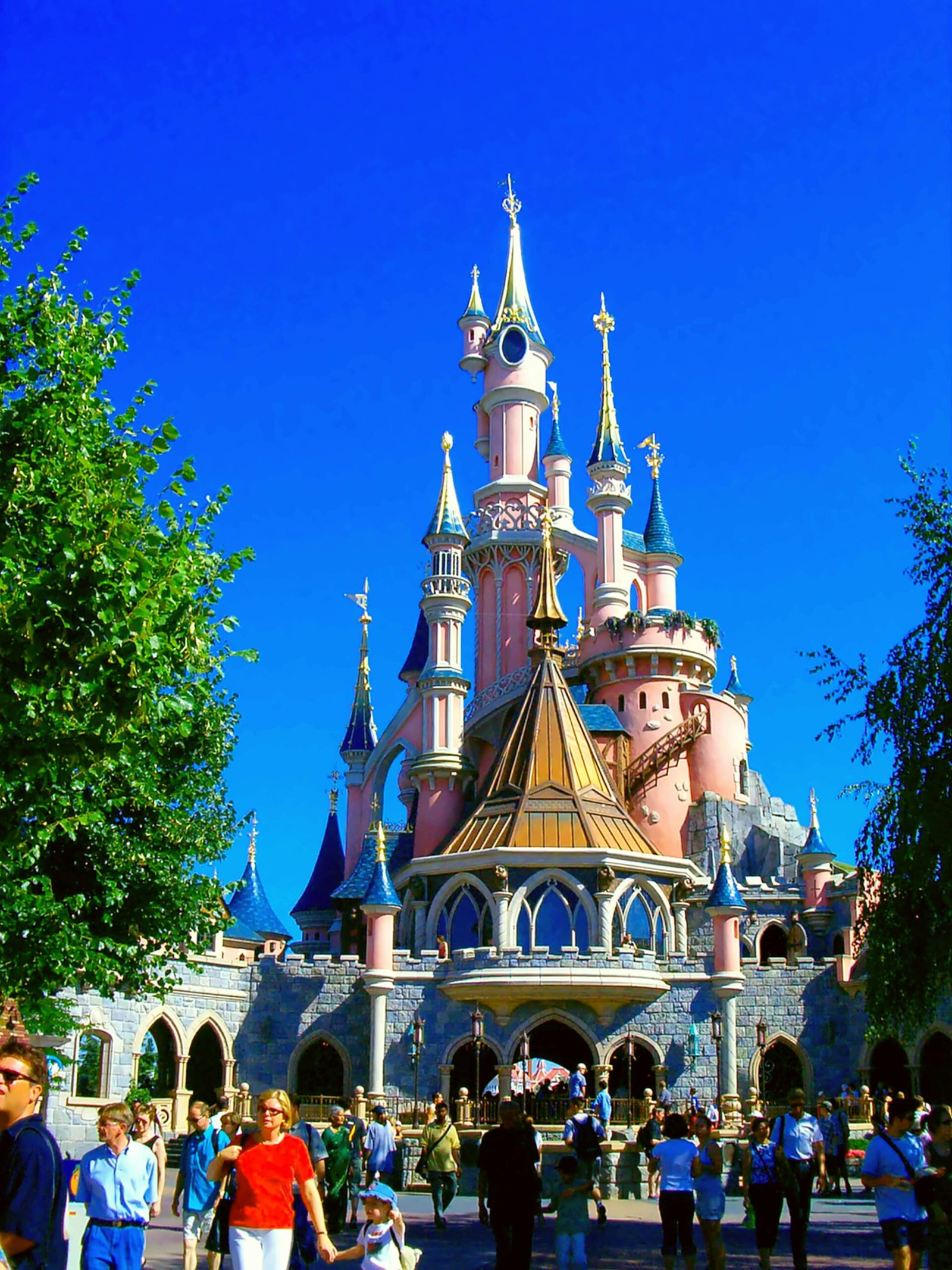 Vibrant view of Sleeping Beauty Castle on a sunny day at Disneyland Paris, a popular tourist attraction.