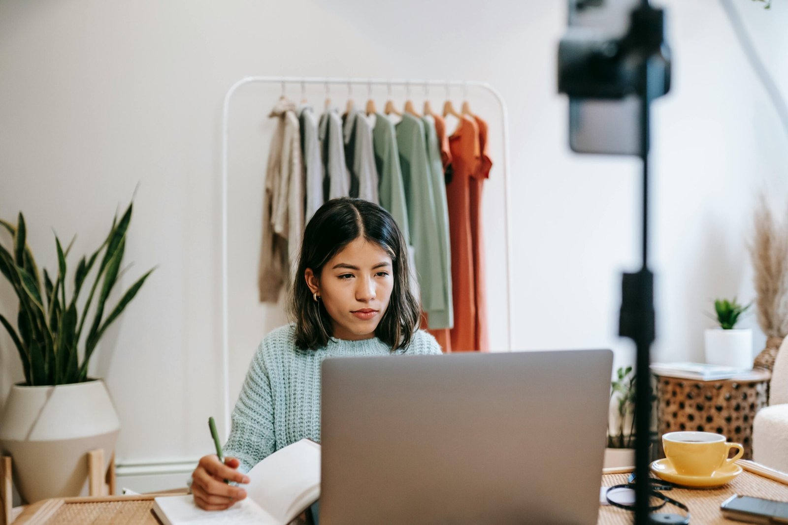 A focused young woman working on a laptop at home, illustrating remote work lifestyle.