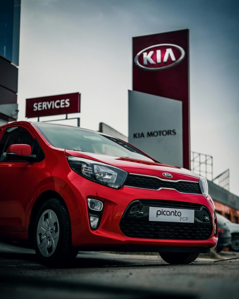 Red Kia Picanto parked at a dealership in Nabeul, Tunisia showcasing its modern design.