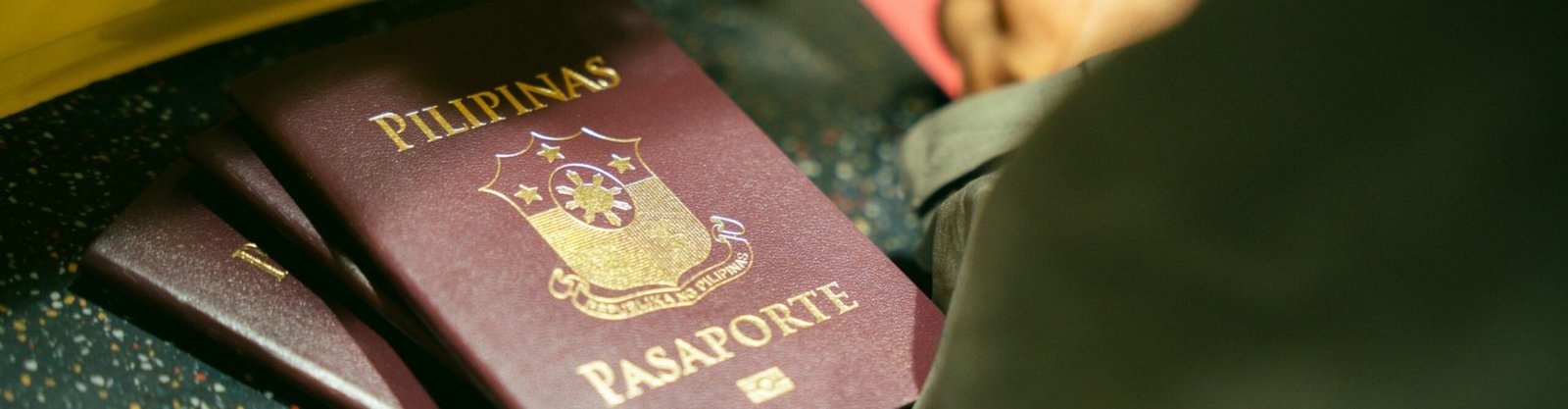 A close-up shot of Filipino passports at the airport, indicating travel and identity.
